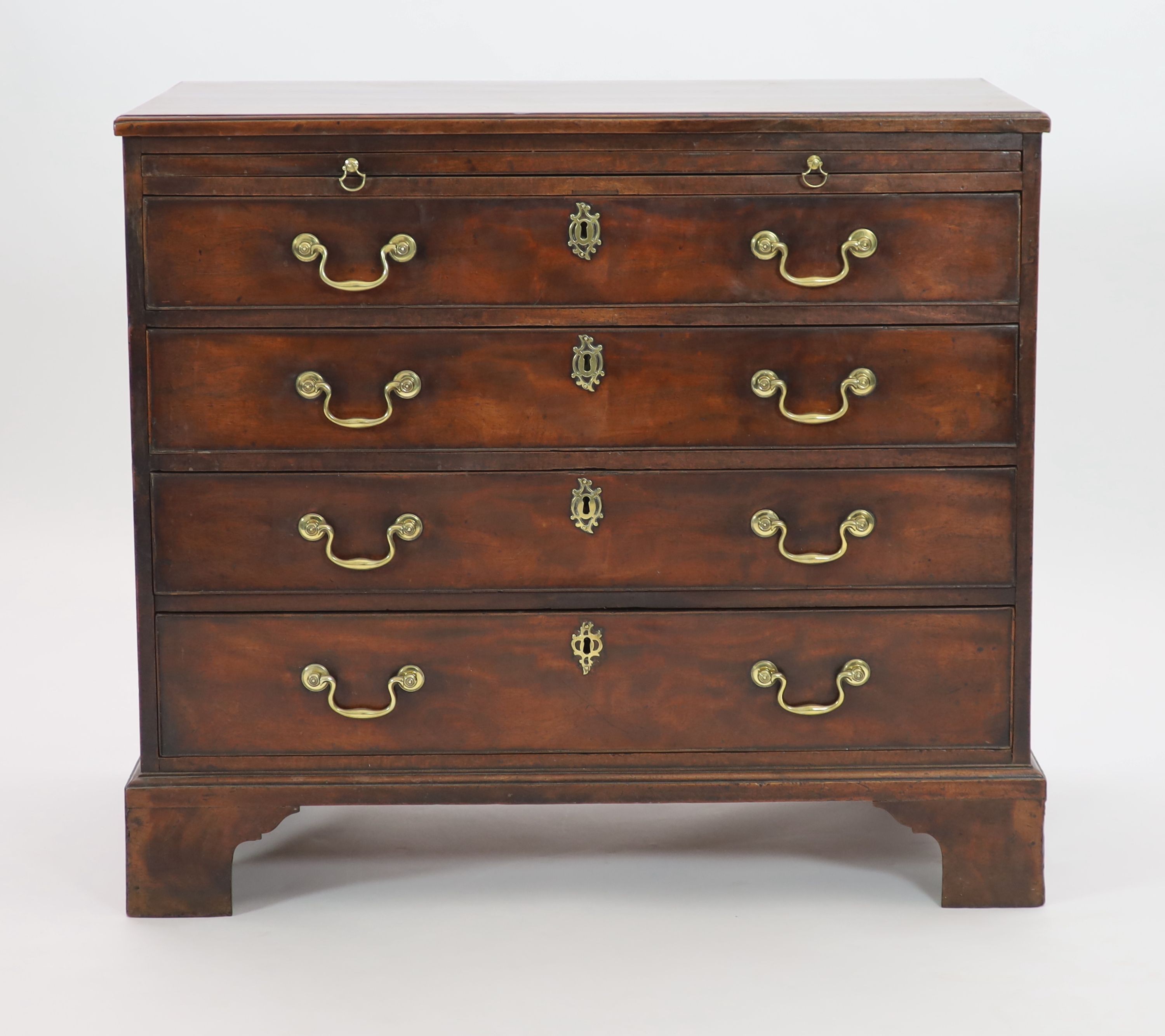 A George III mahogany chest of four graduated long drawers with brushing slide W 93cm D 52cm. H 83cm.